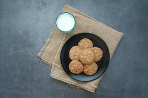 top view of cookies and glass of milk on table photo