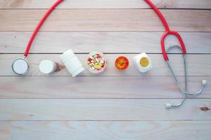 top view of medical pill containers and stethoscope on table photo