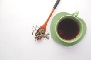 green tea and dry herbal leaf on spoon on white background photo