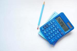 Top view of note pad, calculator, pen on white background. photo