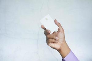 Cerca de la mano de la persona que sostiene la tarjeta de crédito foto