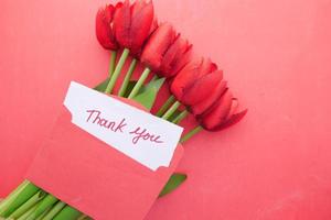 thank you message, envelope o and red tulip flower on ted background photo