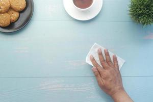 top view of person hand cleaning table with cloth photo