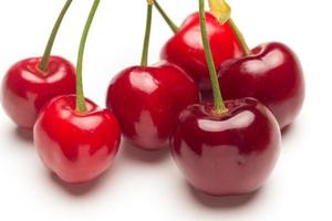 Small red cherries on a white background photo