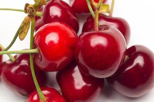 Small red cherries on a white background photo