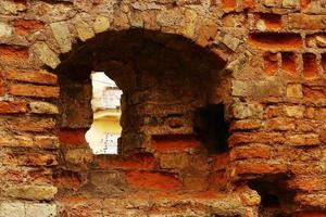 Antiguas ruinas de un antiguo edificio de ladrillo con una pequeña ventana foto