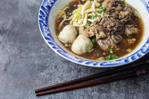 thai boat noodles es la sopa de fideos más famosa de Tailandia, la sopa de fideos thai boat o guay tiew reua, la sopa de fideos de arroz espesa con cerdo guisado y bola de cerdo, cerdo estofado e hígado de cerdo, foto