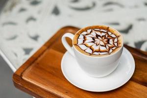 Hot latte art coffee on wood table, relax time photo