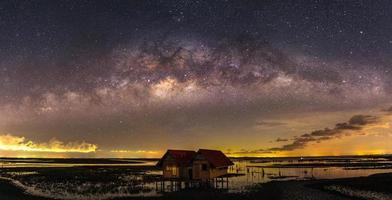 La Vía Láctea -puente sobre Thale Noi y casas gemelas, provincia de Phatthalung, Tailandia- en un día claro y claro foto