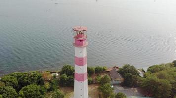 Flying around the lighthouse on the seashore Aerial shot