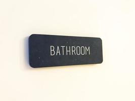 Sign on the white door. Bathroom photo