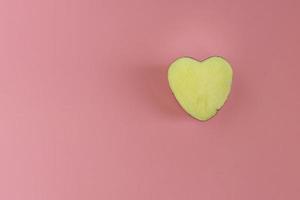 Half heart shaped potatoes on a pink background photo