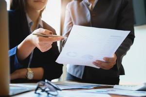 An auditor holds a pen pointing to documents to examine budgets and financial fraud photo