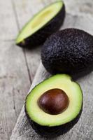 Aguacate orgánico en servilleta de lino sobre fondo de mesa de madera rústica. foto