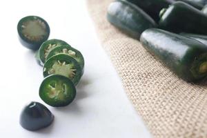 Slices of jalapeno peppers on white background photo