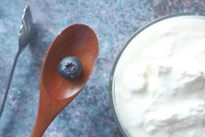 Close up of fresh yogurt with blueberry on a spoon photo