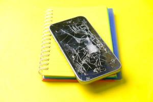 Top view of broken smart phone on yellow background photo