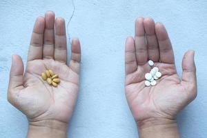 Medicina herbaria y píldoras médicas en la palma de la mano. foto