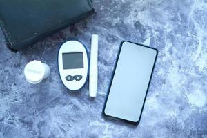 Diabetic measurement tools and smartphone with empty screen photo