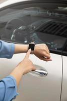 Close up hand using smartwatch to unlock car Photo
