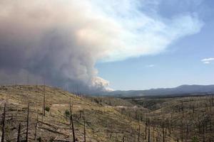 Evidencia de un antiguo incendio forestal en el gila nf con ondulaciones de humo del actual incendio de Johnson en segundo plano. foto