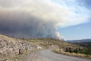 Evidencia de un antiguo incendio forestal en el gila nf con ondulaciones de humo del actual incendio de Johnson en segundo plano. foto