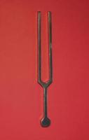 Tuning fork on a red background photo