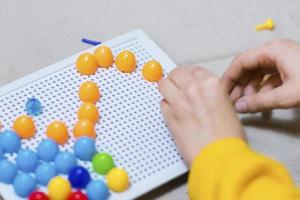 niño jugando juego de mesa de fijación foto