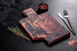 cortar tabla de madera, verduras y una mesa oscura especial