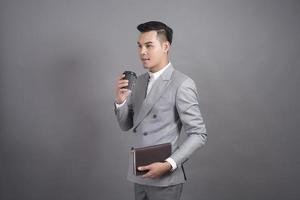 Businessman is drinking coffee break, portrait in studio grey background photo