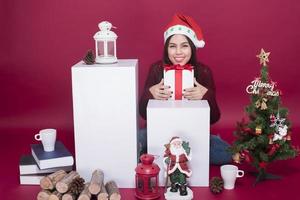 Beautiful Santa Claus girl in studio on red background, Christmas concept photo