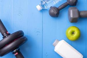 Fitness equipment and Health food on blue wooden background