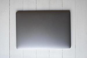 Top view of Laptop computer on white wooden  background photo