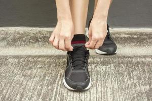 beautiful woman is tying her shoes photo