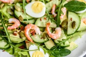 Salad with shrimp, avocado, cucumber, pumpkin seeds and flax seeds with olive oil photo