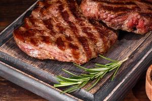 Fresh juicy delicious beef steak on a dark background photo