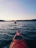 Red canoe or kayak in body of water during daytime photo