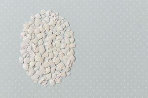 Pieces of white shell chicken egg, folded in the shape of an egg on a blue background photo