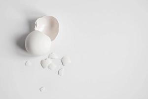 Cáscara de huevo blanca de un huevo de gallina roto con fragmentos aislado sobre un fondo blanco. foto