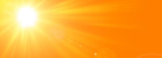 Sunny summer background with the bright sun on an orange background photo