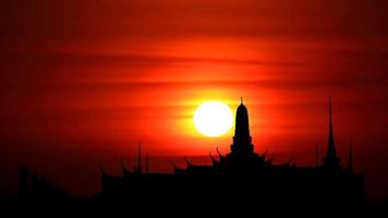 coucher de soleil et lever de lune sur la silhouette d'un temple bouddhiste video