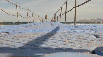 L'homme avec un seau lave la jetée du ponton sur le pont video