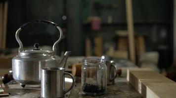 tetera de acero, tazas de acero inoxidable y una lata de hojas de té