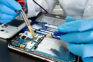 Technician repairing inside of mobile phone by soldering iron. Integrated Circuit. the concept of data, hardware, technology. photo