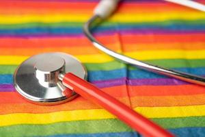 Black stethoscope on rainbow flag background, symbol of LGBT pride month celebrate annual in June social, symbol of gay, lesbian, bisexual, transgender, human rights and peace. photo