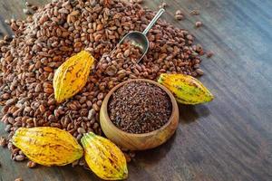 cocoa nibs and cocoa fruit on wooden table photo