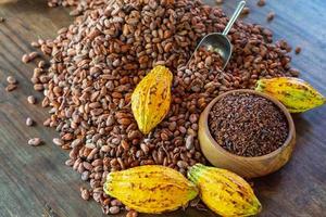 Nibs de cacao y frutos de cacao en la mesa de madera foto