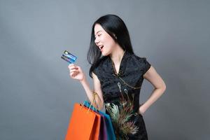 Asian woman wear Chinese traditional dress with shopping bag and credit card photo