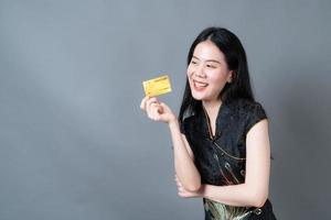 Asian woman wear Chinese traditional dress with hand holding credit card photo