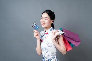 Asian woman wear Chinese traditional dress with shopping bag and credit card photo